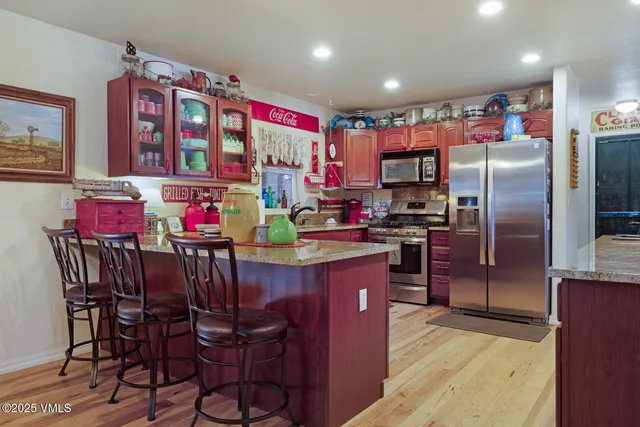 a kitchen that has a dining table cabinets and stainless steel appliances