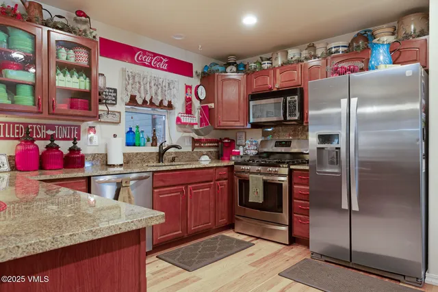 a kitchen with stainless steel appliances granite countertop a refrigerator and a sink