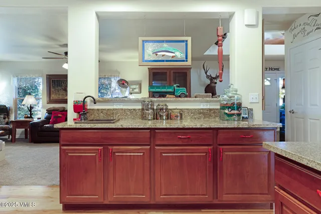 a living room with granite countertop a sink and a wooden floor