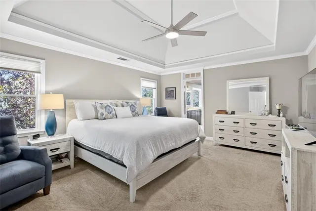 a bedroom with a bed and a flat tv screen on dresser
