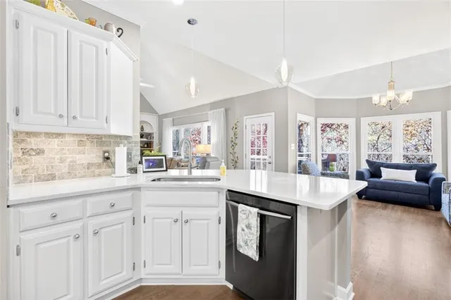 a kitchen with a refrigerator a stove and a sink with wooden floor