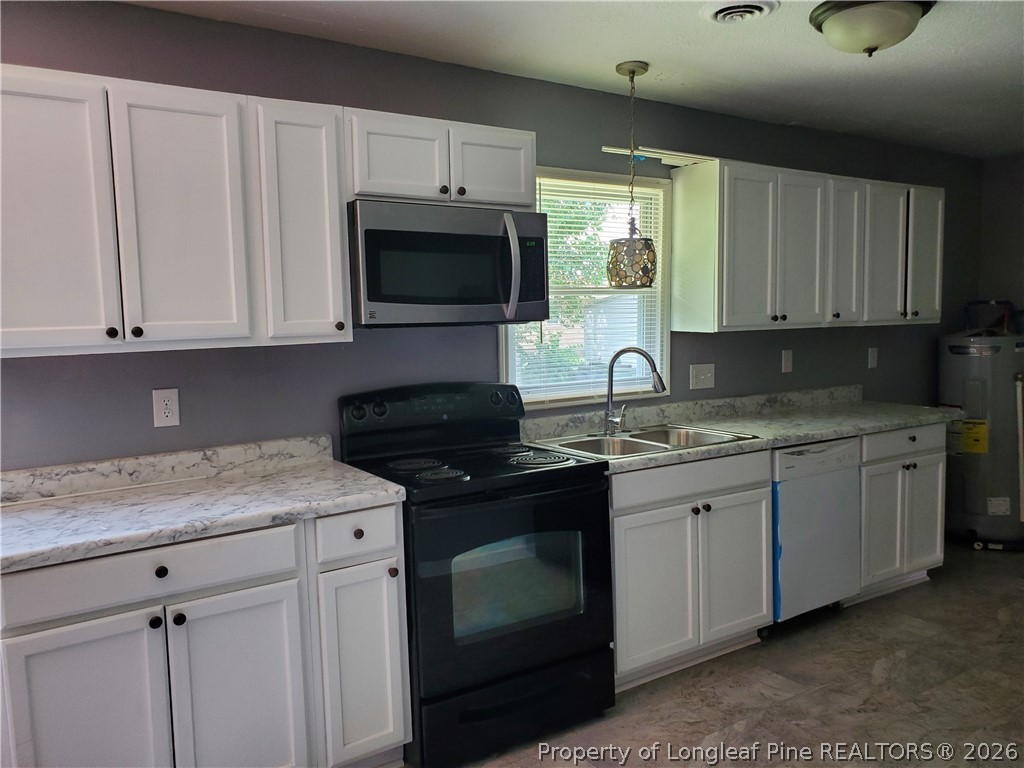 724 Spruce Street Lumberton, NC 28358 - Photo 4 of 13 a kitchen with granite countertop white cabinets sink and stainless steel appliances