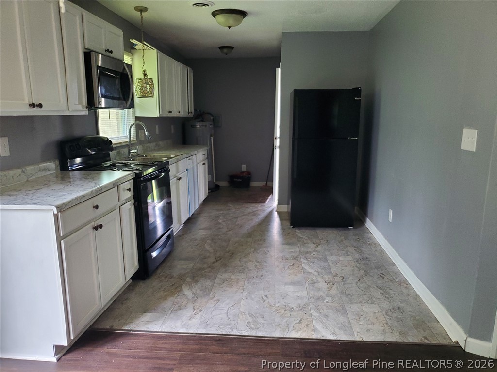 724 Spruce Street Lumberton, NC 28358 - Photo 5 of 13 a kitchen with stainless steel appliances granite countertop a stove a sink and a refrigerator