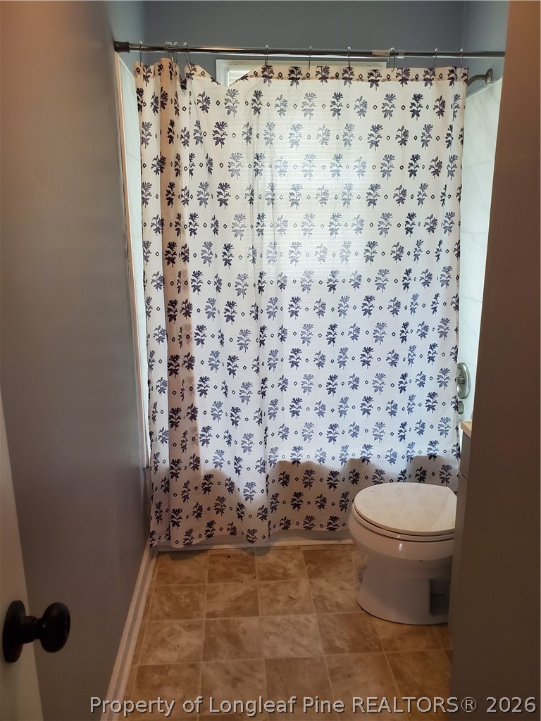 724 Spruce Street Lumberton, NC 28358 - Photo 10 of 13 a bathroom with a toilet and a shower curtain