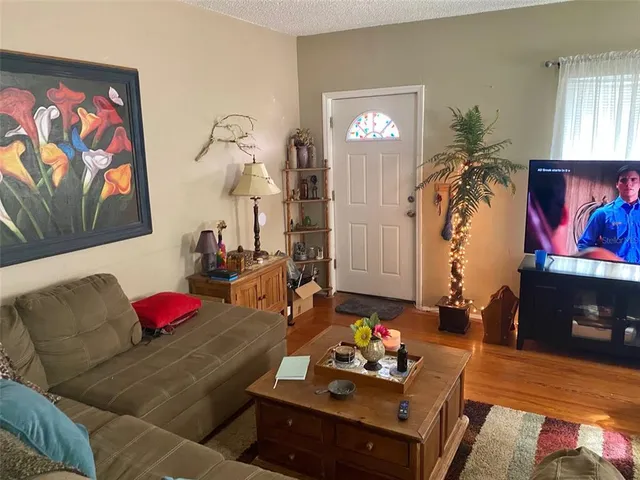 a living room with furniture and a wooden floor
