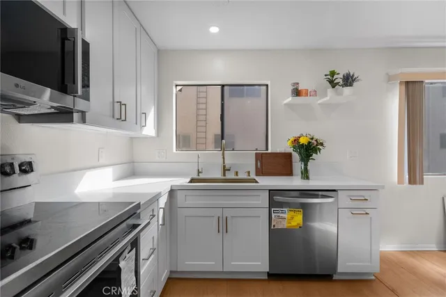 a kitchen with stainless steel appliances white cabinets a sink and a stove