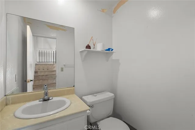 a bathroom with a sink toilet and a mirror