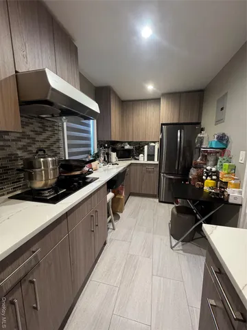 a kitchen with refrigerator and chairs