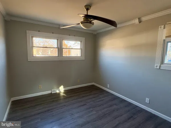 a empty room with wooden floor and windows