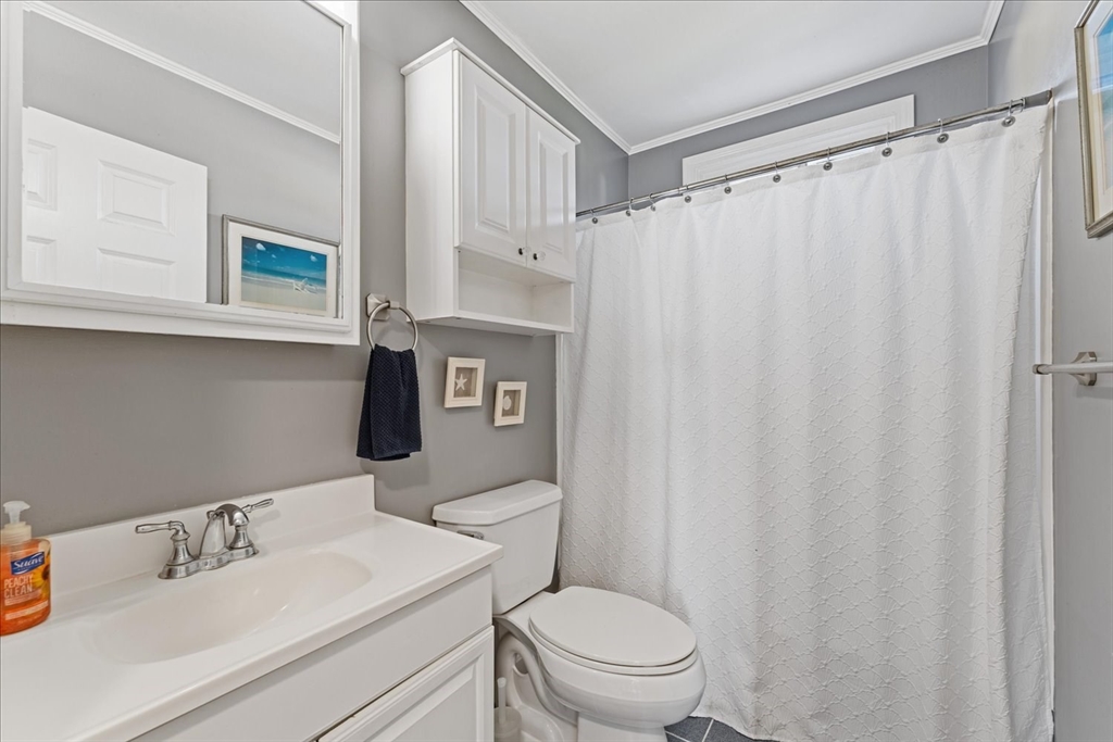 45 Tupelo Road South Kingstown, RI 02879 - Photo 16 of 28 a bathroom with a sink a toilet and shower curtain