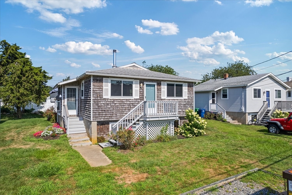 45 Tupelo Road South Kingstown, RI 02879 - Photo 3 of 28 a front view of a house with a yard table and chairs