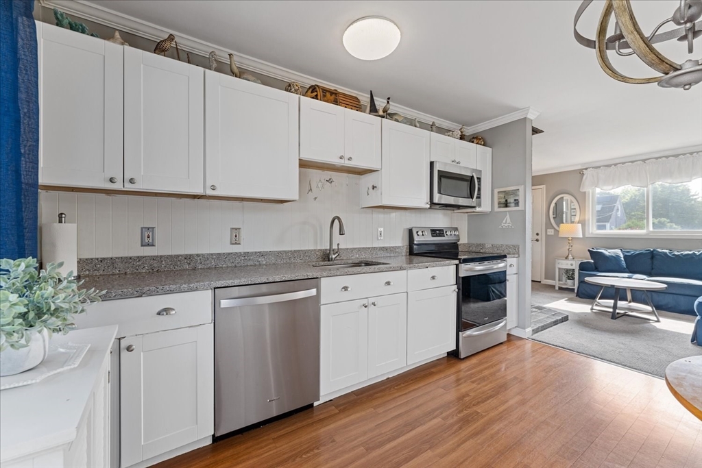 45 Tupelo Road South Kingstown, RI 02879 - Photo 9 of 28 a kitchen with granite countertop white cabinets and white appliances