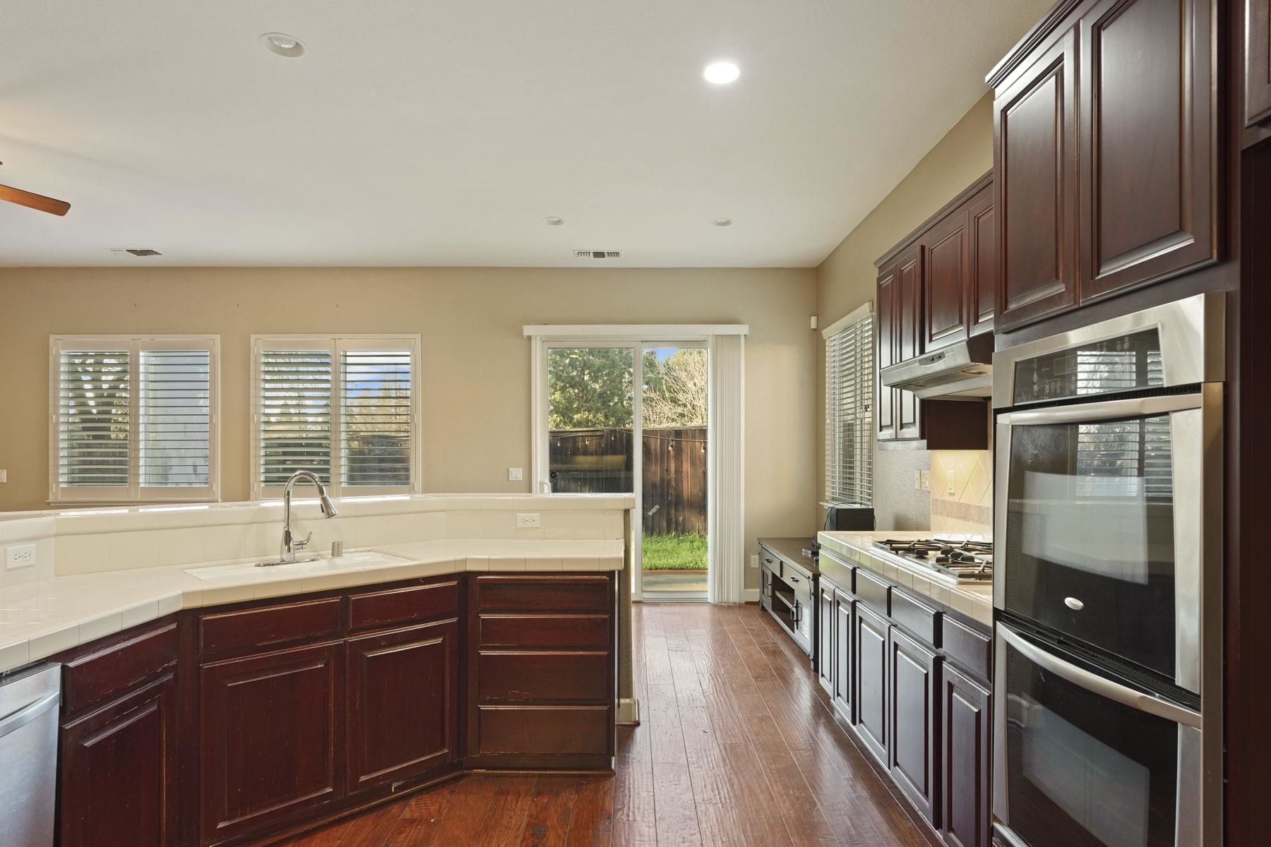 2644 Swainsons Hawk Street Stockton, CA 95209 - Photo 11 of 41 a kitchen with stainless steel appliances sink stove microwave and wooden cabinets