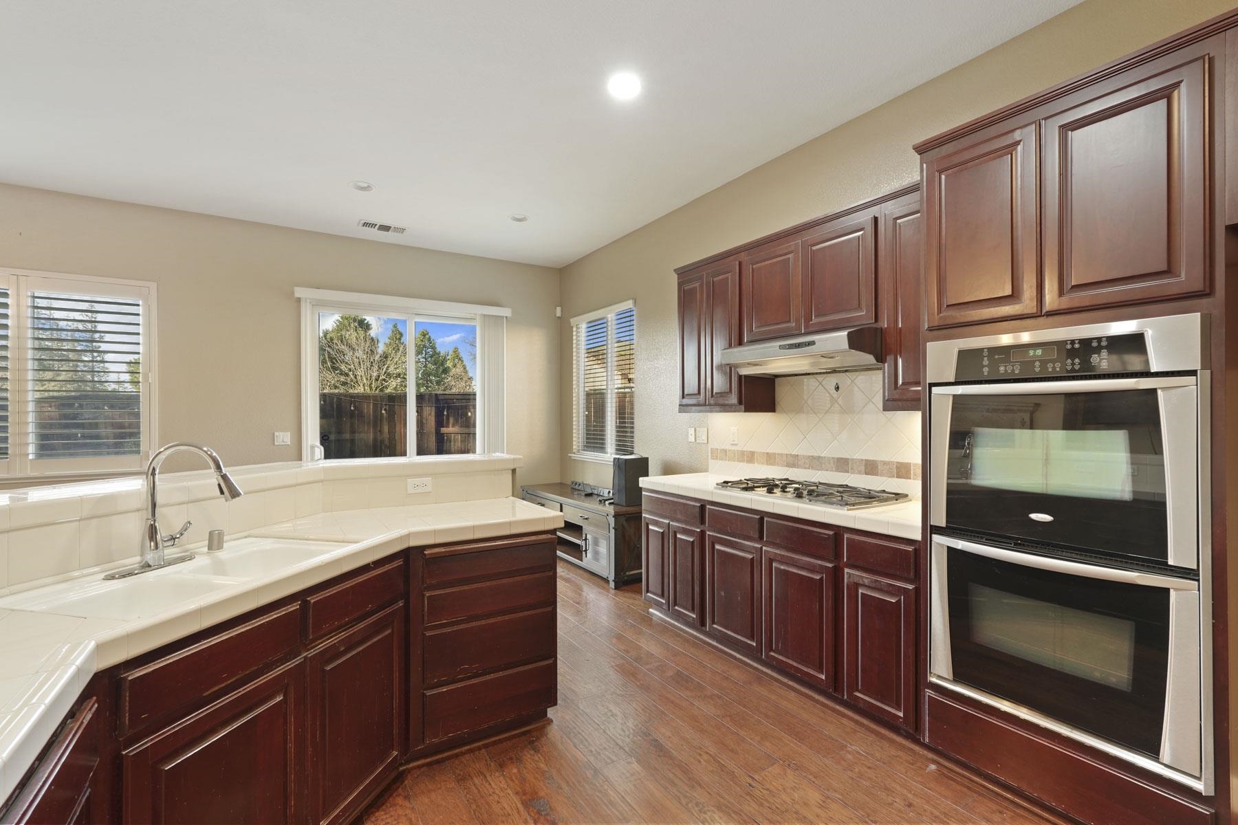 2644 Swainsons Hawk Street Stockton, CA 95209 - Photo 12 of 41 a kitchen with stainless steel appliances granite countertop a stove a sink and a microwave