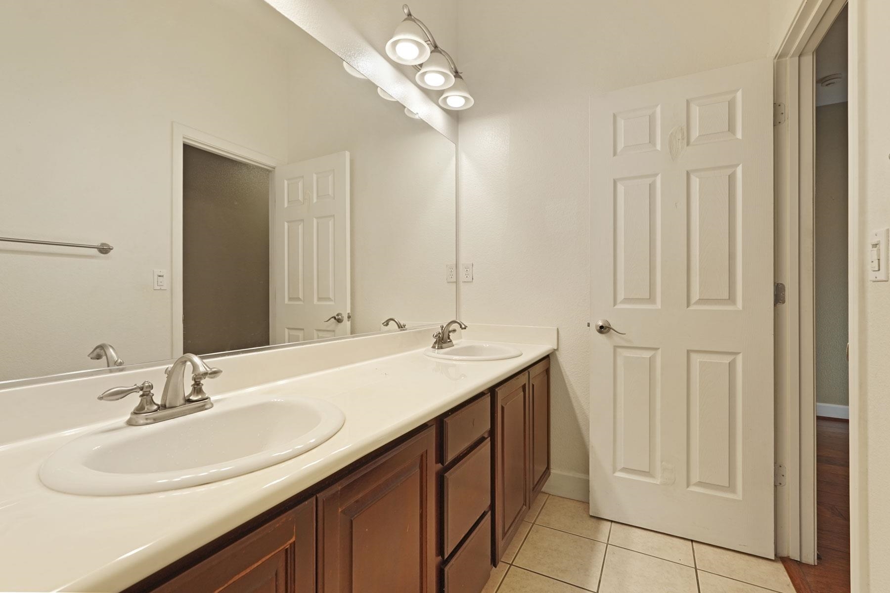 2644 Swainsons Hawk Street Stockton, CA 95209 - Photo 16 of 41 a bathroom with a double vanity sink and a mirror