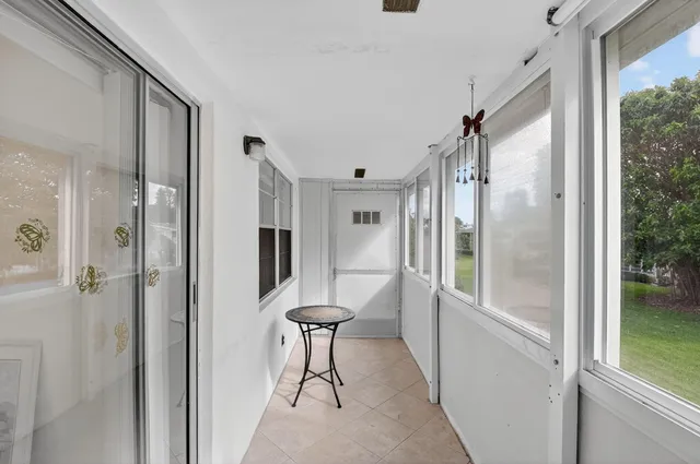 a view of a hallway with a glass door and furniture
