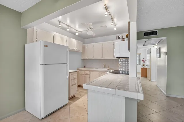 a kitchen with a refrigerator a sink and cabinets