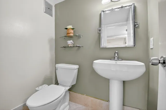 a bathroom with a toilet sink and mirror