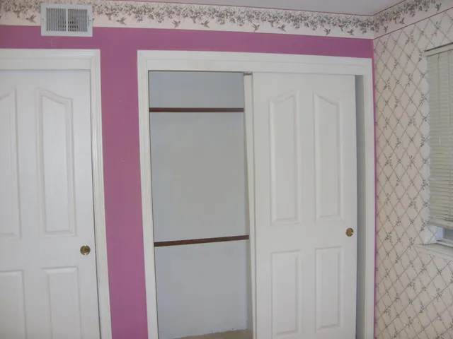 a view of a livingroom with a chandelier fan and a bathroom