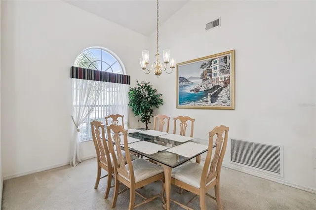 a view of a dining room with furniture and chandelier