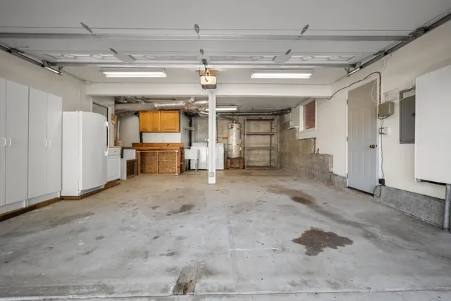 a view of a house with a porch garage and a large tree
