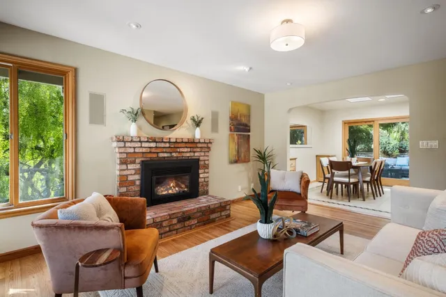 a kitchen with stainless steel appliances granite countertop a refrigerator a stove a sink a dining table and chairs