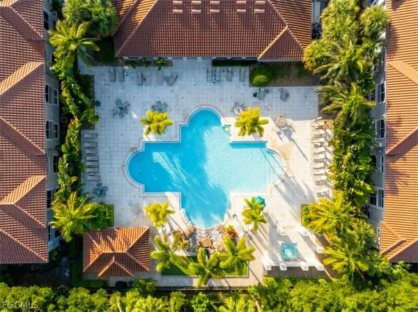 a aerial view of a house with swimming pool and large trees
