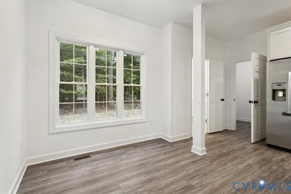 an empty room with wooden floor and a window