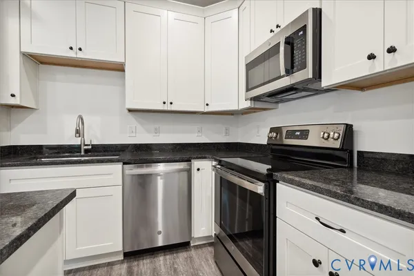 a kitchen with stainless steel appliances granite countertop a sink and a stove