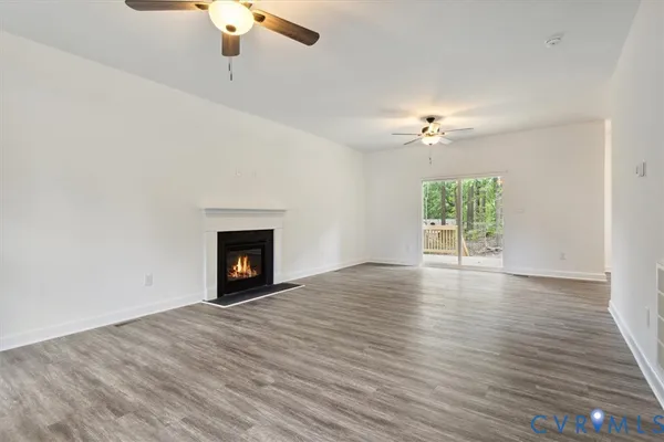 a view of an empty room with a fireplace and a window