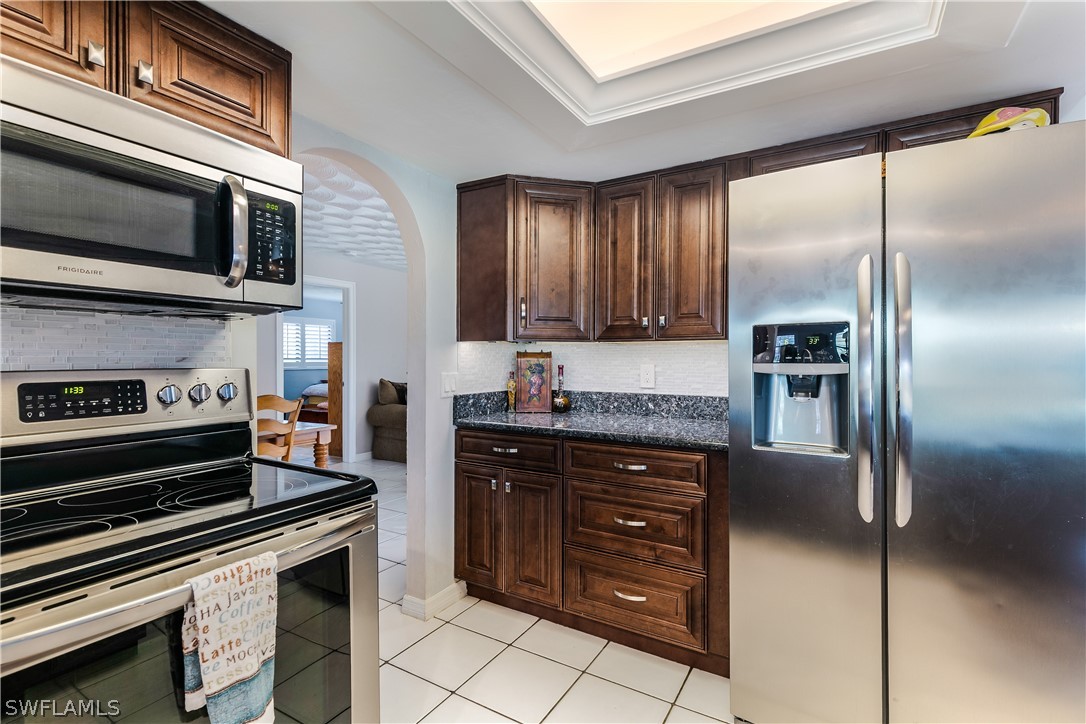 7635 Laurel Valley Road Fort Myers, FL 33967 - Photo 4 of 30 a kitchen with stainless steel appliances granite countertop a stove microwave and refrigerator