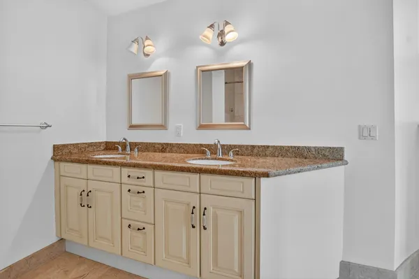 a bathroom with a granite countertop sink and a mirror