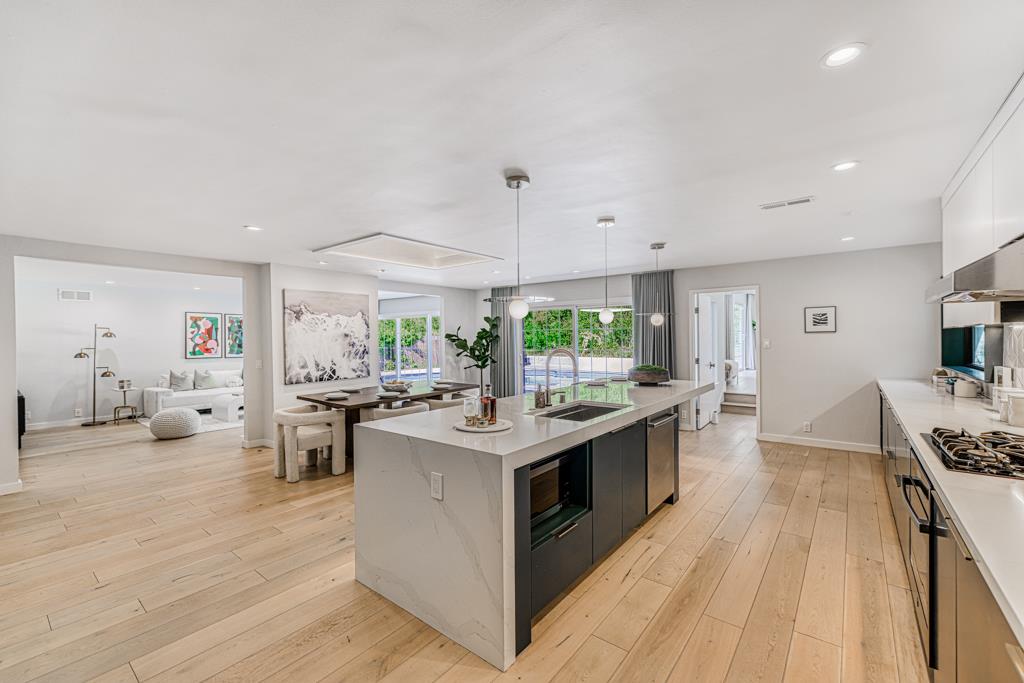 1349 Murchison Drive Millbrae, CA 94030 - Photo 32 of 66 a large kitchen with stainless steel appliances a stove a sink dishwasher and a fireplace with wooden floor