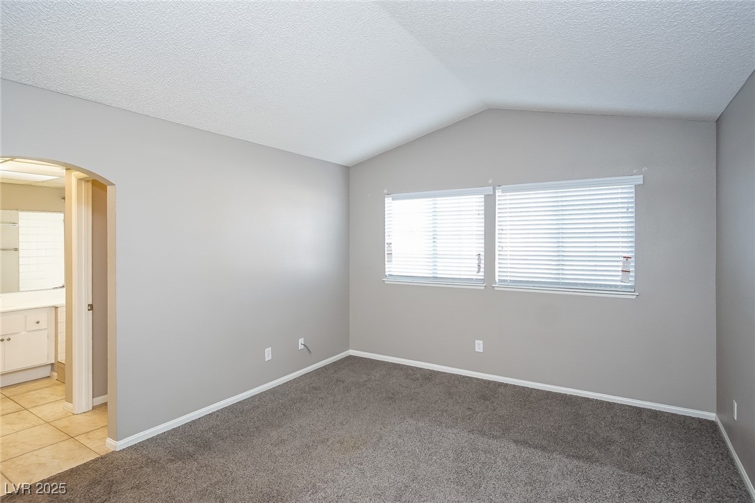 7118 Shadow Crest Drive Las Vegas, NV 89119 - Photo 8 of 15 Empty room featuring a textured ceiling, arched wa