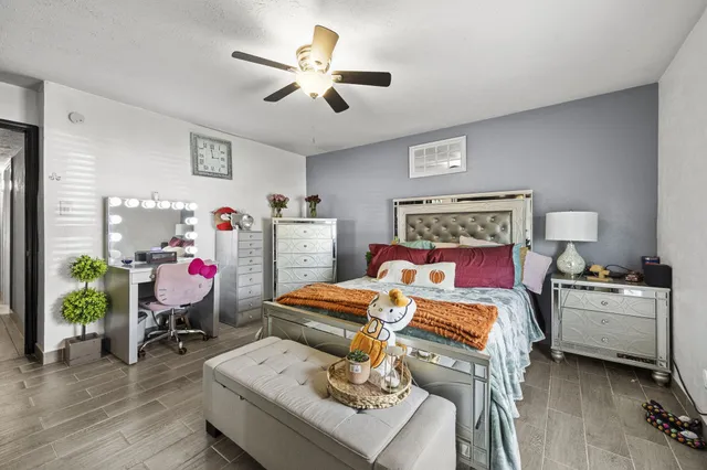 a bedroom with furniture and a wooden floor