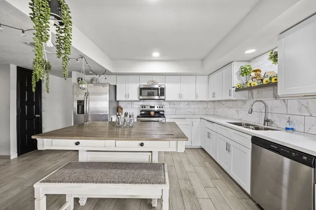 a kitchen with stainless steel appliances granite countertop a sink a stove and a refrigerator