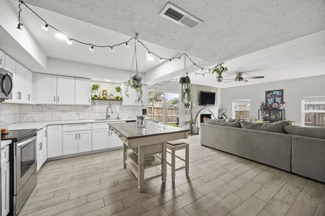 a kitchen with stainless steel appliances kitchen island granite countertop a sink and cabinets