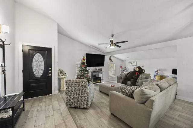 a living room with furniture a flat screen tv and a fireplace