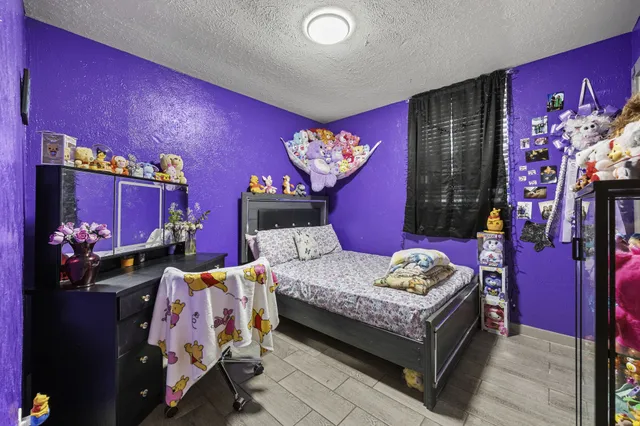 a bedroom with a bed and dresser with mirror