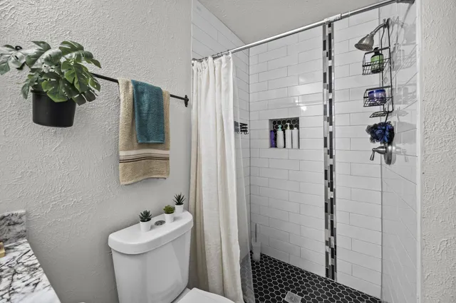a bathroom with a shower a toilet and a sink