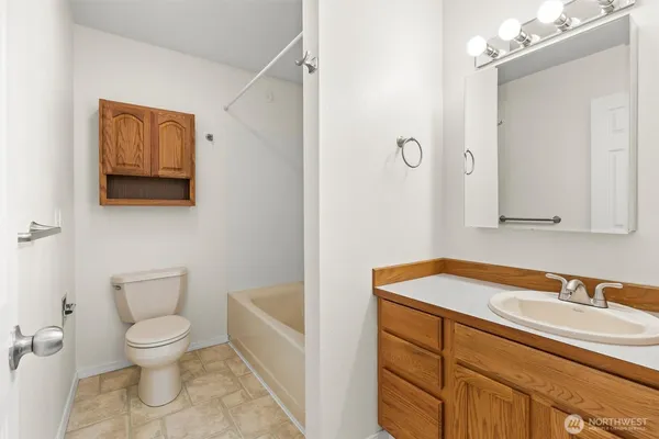 a bathroom with a granite countertop sink a toilet and a mirror