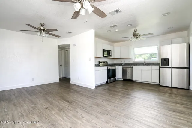 a view of a kitchen with a sink stainless steel appliances and cabinets