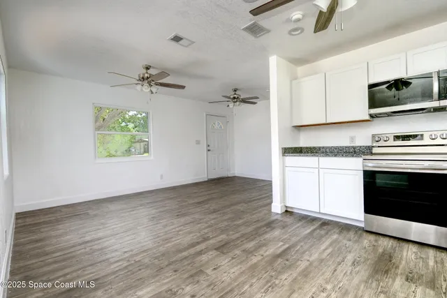 a view of a kitchen with a stove cabinets and wooden floor