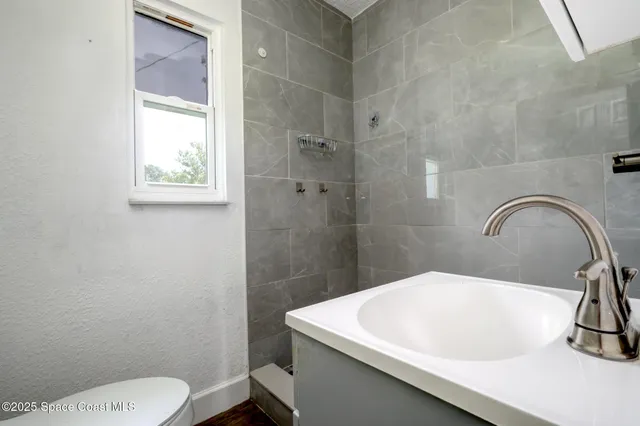 a bathroom with a sink a toilet and a shower