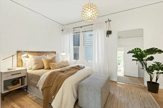 a bedroom with a bed and a potted plant