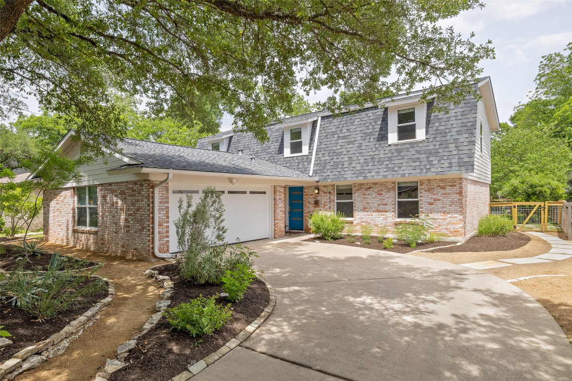 a front view of a house with garden and parking