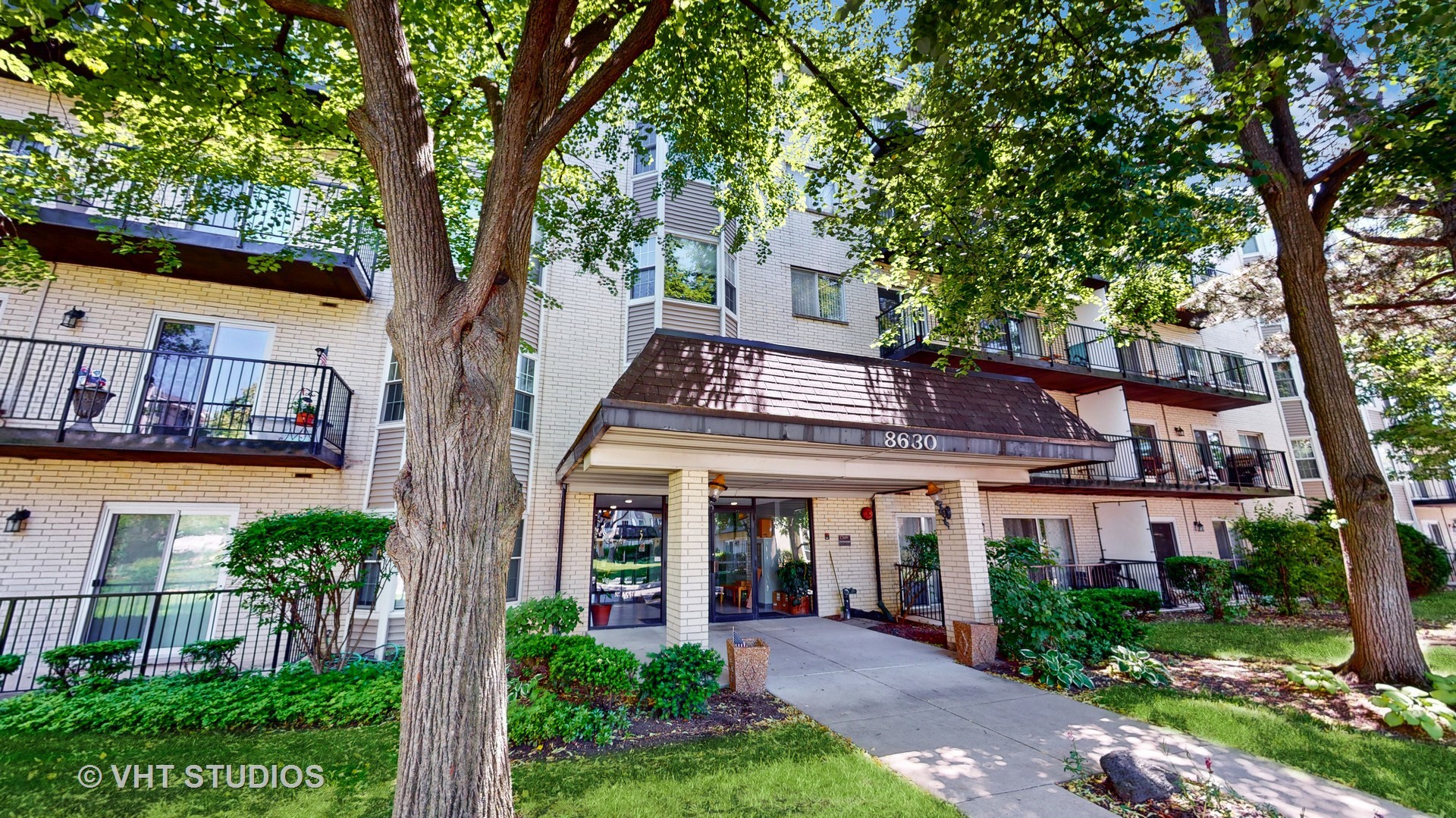 8630 Waukegan Road, Unit 519 Morton Grove, IL 60053 - Photo 1 of 26 a view of a white house next to a large tree