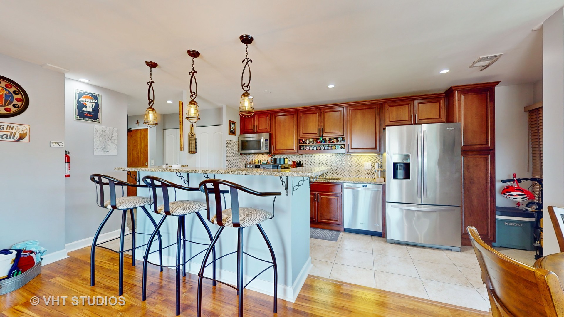 8630 Waukegan Road, Unit 519 Morton Grove, IL 60053 - Photo 11 of 26 a kitchen with stainless steel appliances granite countertop a refrigerator a microwave oven a sink with island and chairs