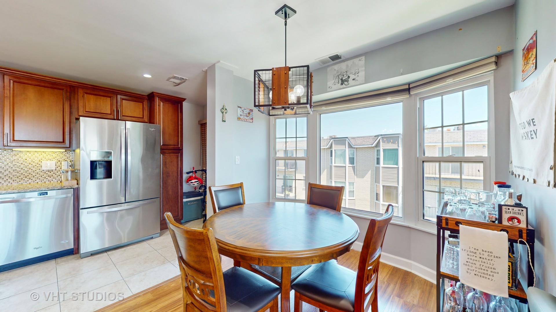 8630 Waukegan Road, Unit 519 Morton Grove, IL 60053 - Photo 7 of 26 a kitchen with stainless steel appliances granite countertop a refrigerator a kitchen island a table and chairs