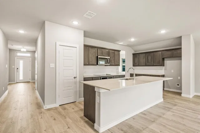 a large white kitchen with wooden floor